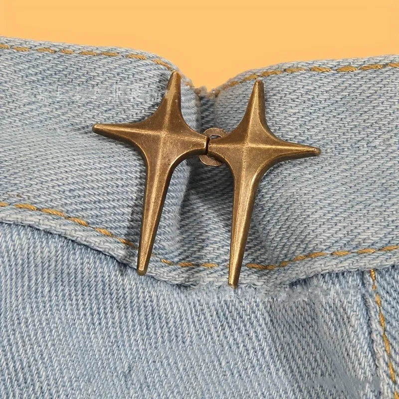 A pair of gold star-shaped decorative buttons fastened onto light blue denim fabric.