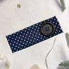 Navy fabric hairband with white polka dots and a black button closure on a white background.