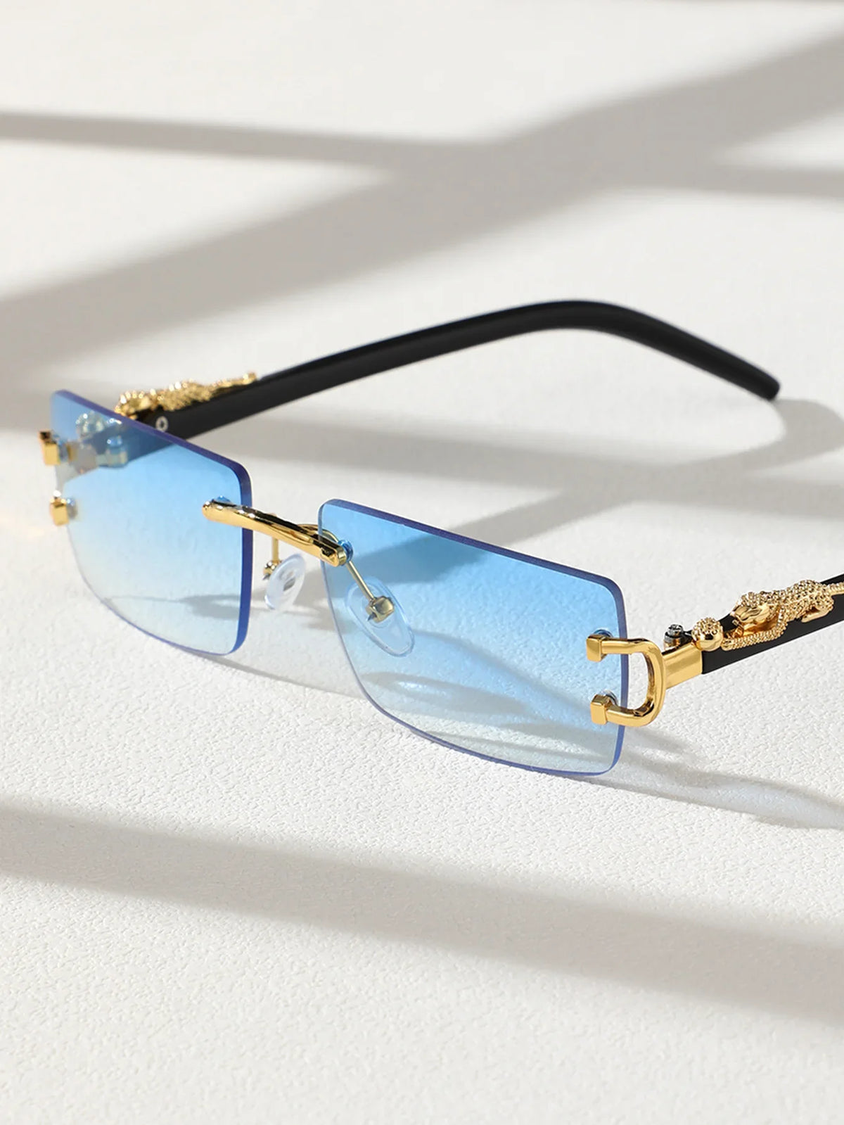 Trendy frameless rectangular sunglasses with light blue lenses and gold accents