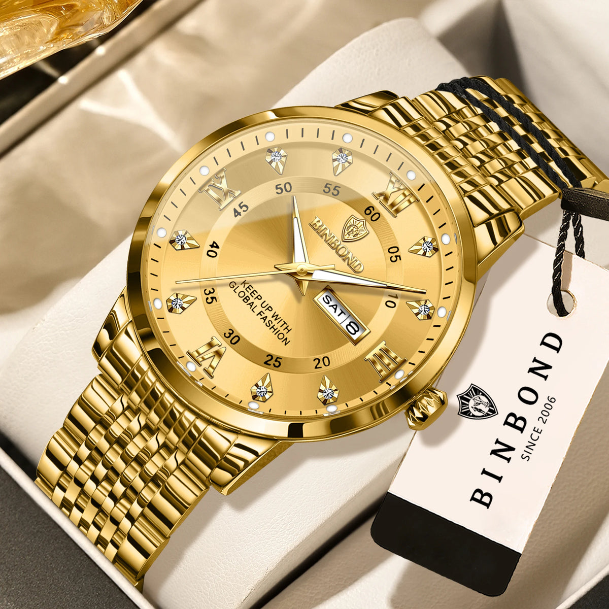 A gold watch with a leather strap is displayed on a white box.