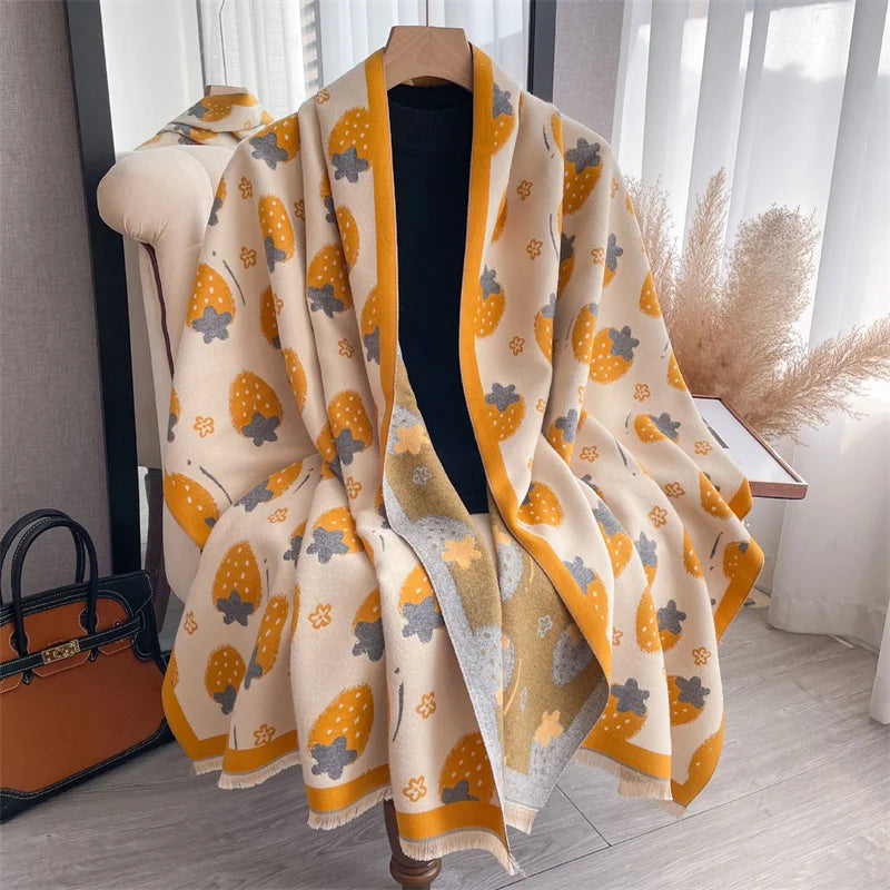 A beige and yellow patterned cashmere scarf and shawl wrap displayed on a hanger.