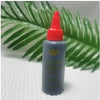 A bottle of Hair London Glue with a red cap and a gold crown design, set against a green palm leaf background.