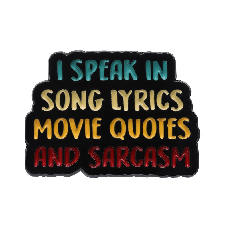 Pin de esmalte negro con texto dorado y turquesa que dice 'Hablo en letras de canciones, citas de películas y sarcasmo'
