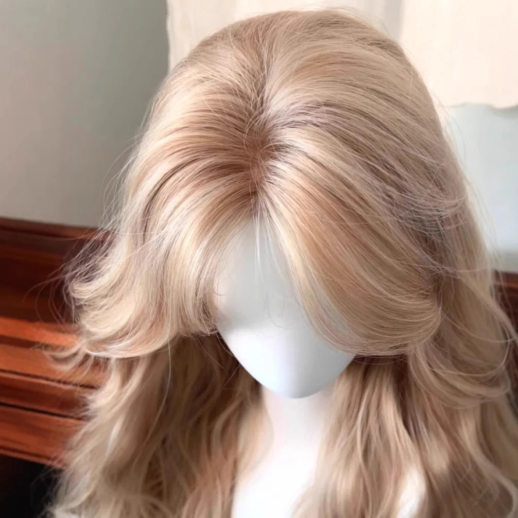 Primer plano de una peluca rubia exhibida en un maniquí, mostrando cabello largo y ondulado y flequillo.