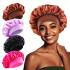 Une femme modélise divers bonnets pour cheveux en satin de soie dans des tons de cuivre, violet, noir et rose.