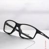 A pair of black photochromic dual-light reading glasses resting on a white surface.