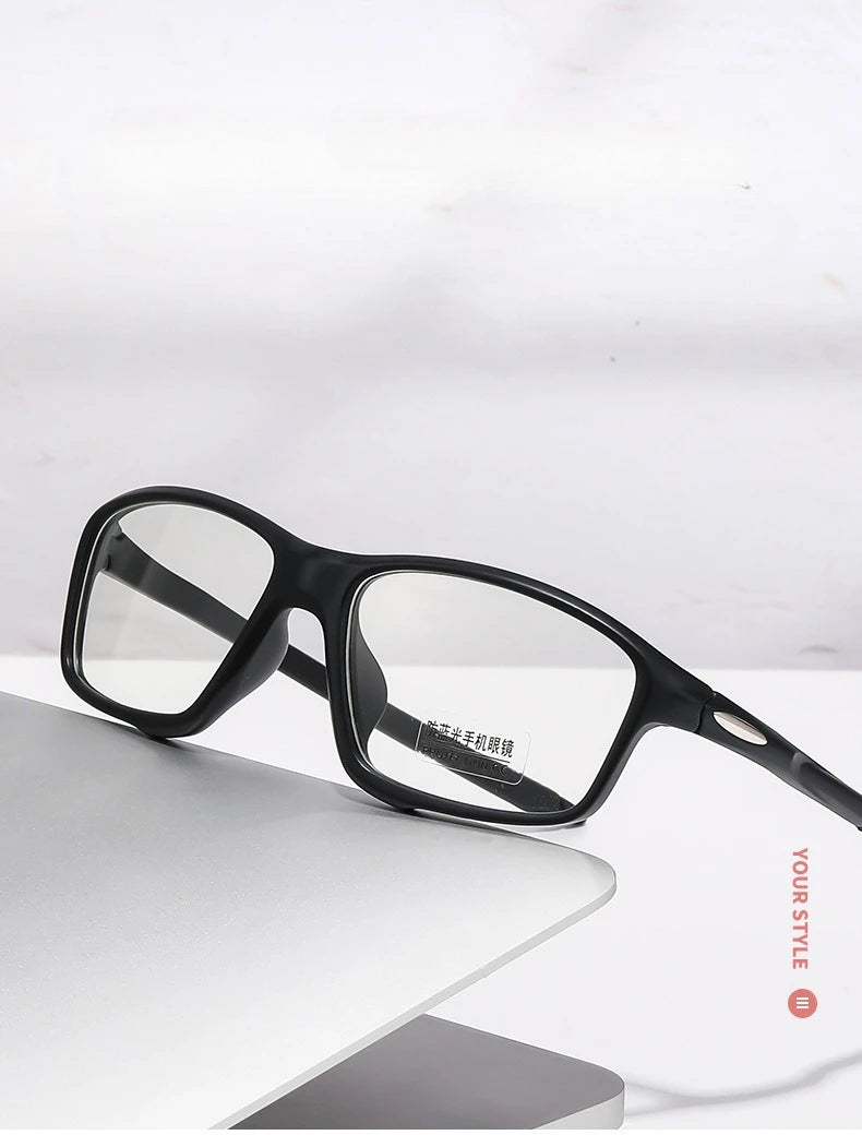 A pair of black photochromic dual-light reading glasses resting on a white surface.