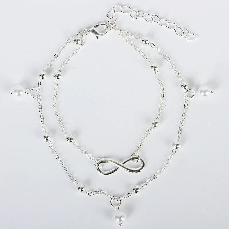 A delicate silver-plated friendship anklet featuring a chain and an infinity symbol charm.