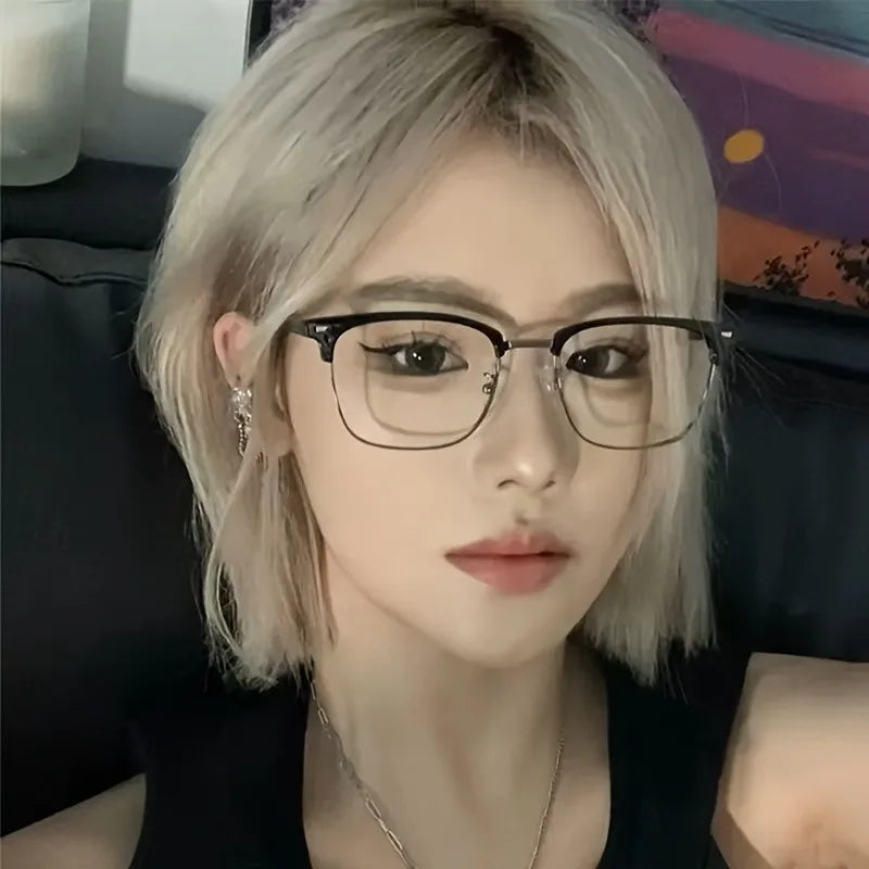 A close-up portrait of a woman wearing black-framed anti blue light eyewear with light blonde hair.