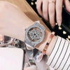 A close-up of a luxury women's watch with a diamond-encrusted rotating bezel and rose gold band on a wrist.