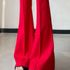 A close-up shot of bright red high-waist flare skinny pants worn by a person.