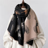 A black and beige luxury plaid cashmere feel scarf and shawl wrap draped over a mannequin.