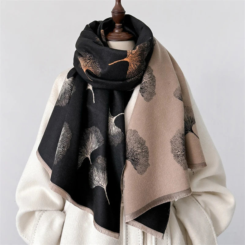 A black and beige luxury plaid cashmere feel scarf and shawl wrap draped over a mannequin.