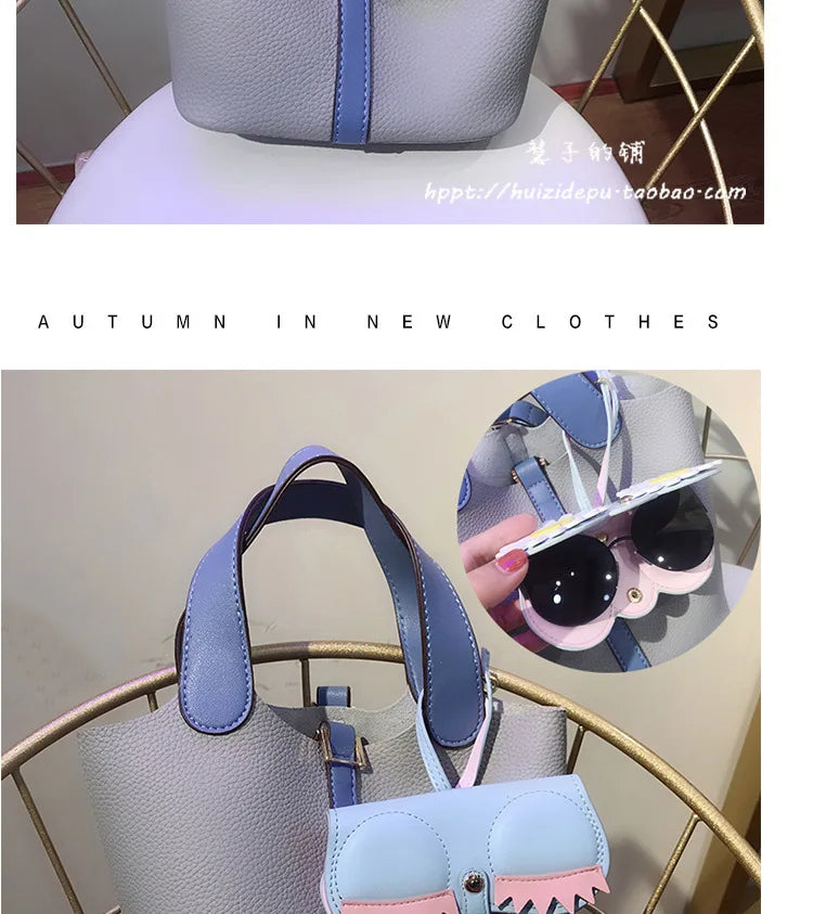 A light blue and pink portable eyewear storage pouch is displayed on a gold-toned stand.
