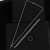 Collier et chaîne en acier inoxydable argenté, présenté sur fond noir.