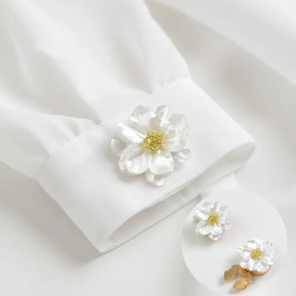 Manche en tissu blanc avec un bouton floral nacré délicat