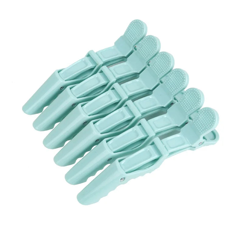 A set of six light blue alligator hair sectioning clips arranged in a row.