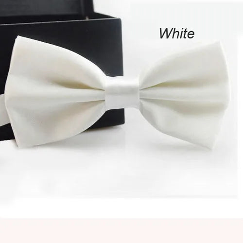Un nœud papillon classique blanc est montré sur un fond sombre.