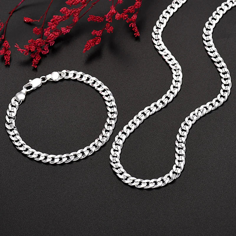 Un ensemble de colliers et bracelets en argent sterling 925, présentés sur un fond sombre avec du feuillage rouge.