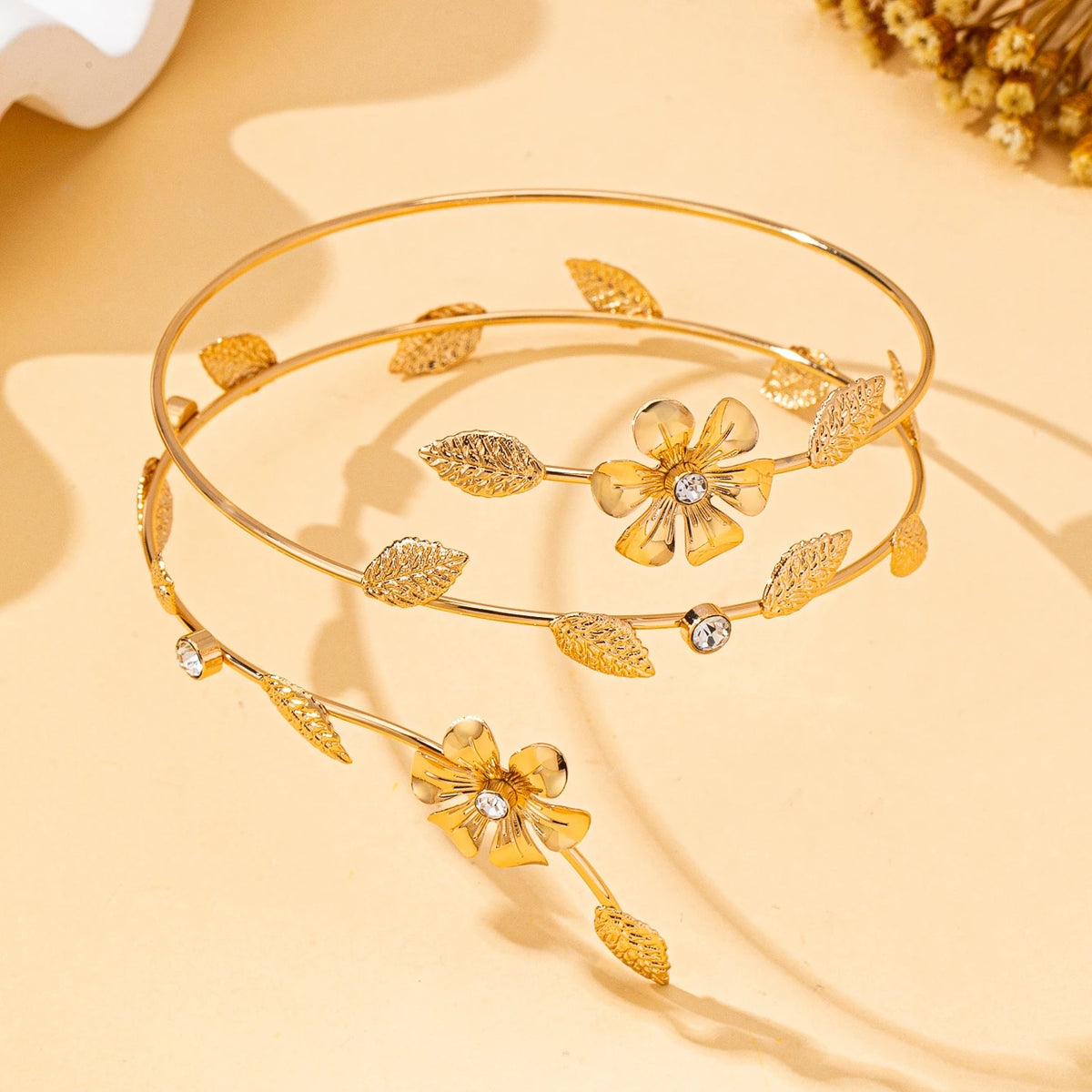 Gold floral vine arm bracelet with small gold leaves and clear stones