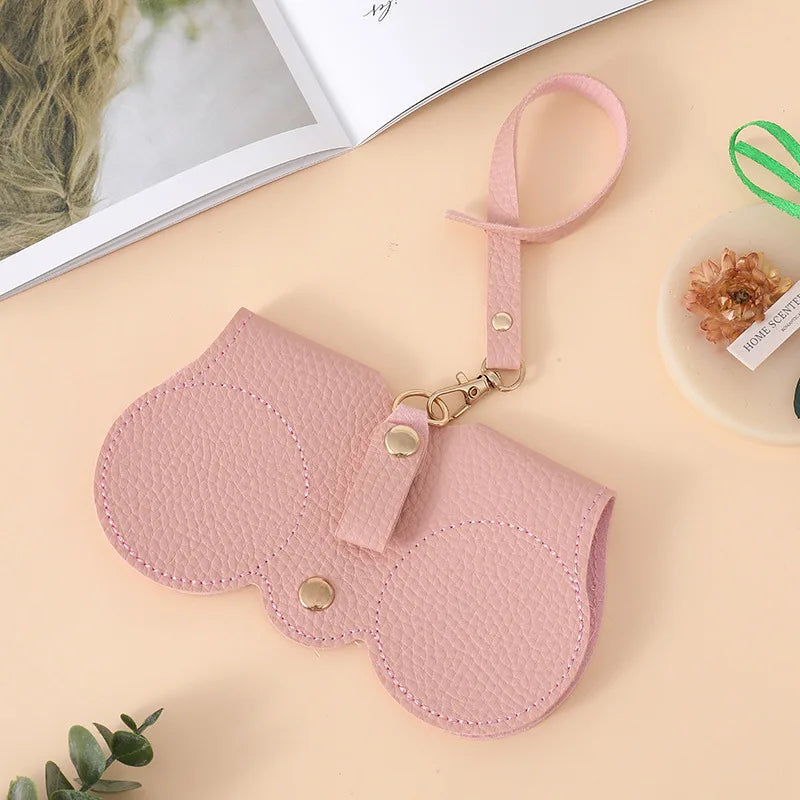 A pink leather pouch for storing portable eyewear, featuring a loop for carrying.
