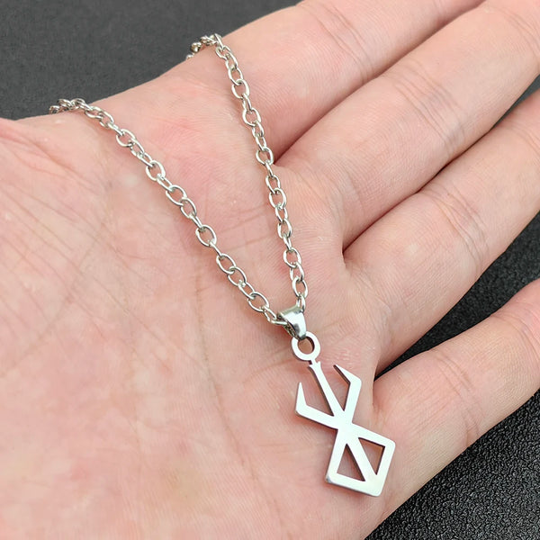 Silver chain necklace with an anime berserk sword logo pendant worn on a hand.