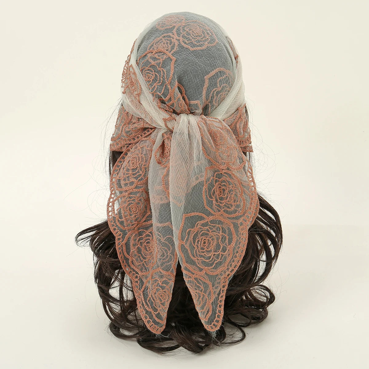 A floral embroidered lace bandana headscarf tied around a person's hair.