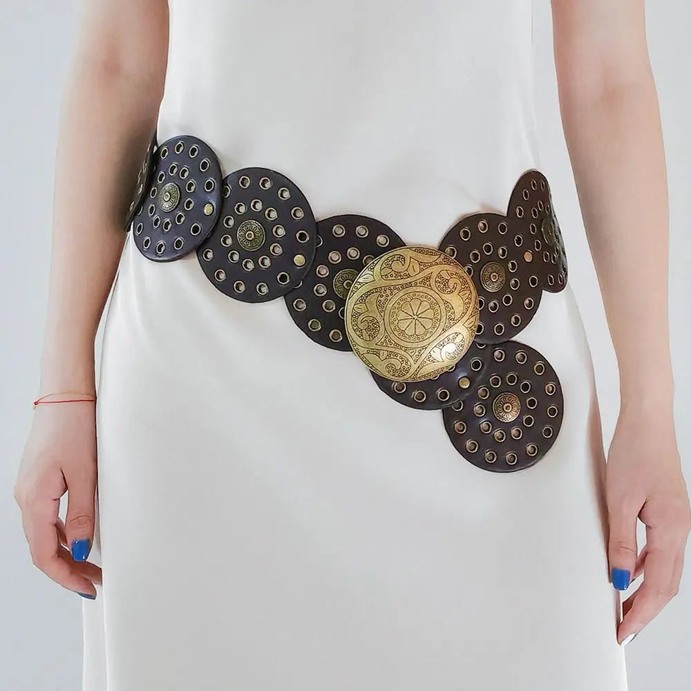 A close-up of a white dress featuring vintage PU disc belts with metal buckles on the waist.