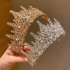 Primer plano de una elegante tiara para el cabello de pedrería barroca con intrincados cristales de oro y claros.
