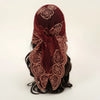 A deep burgundy floral embroidered lace bandana headscarf tied around dark hair.