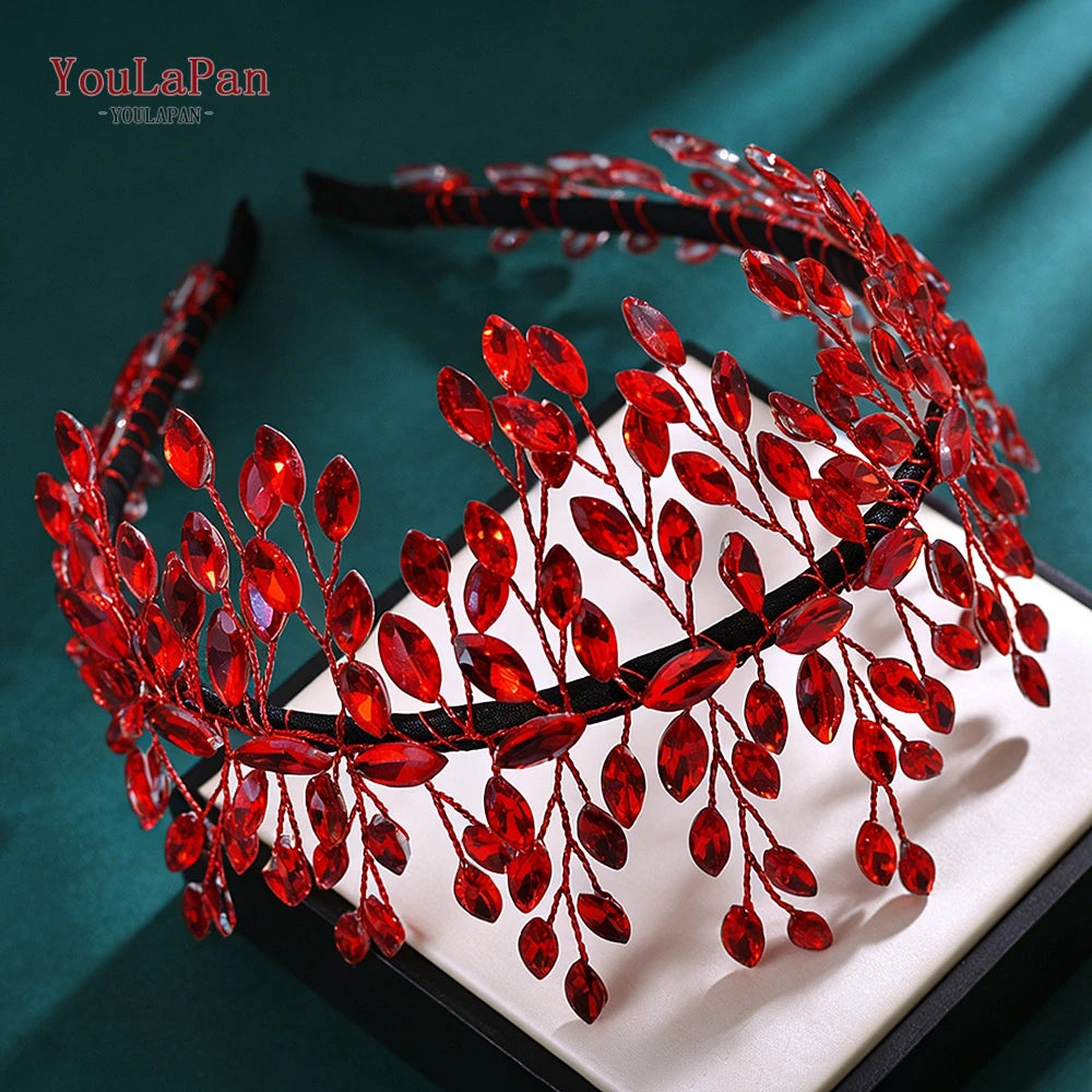 A close-up of a red rhinestone bridal headband featuring delicate leaves and berries.
