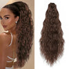Une femme montre de longues extensions de cheveux bouclés brun foncé en queue de cheval volumineuse.