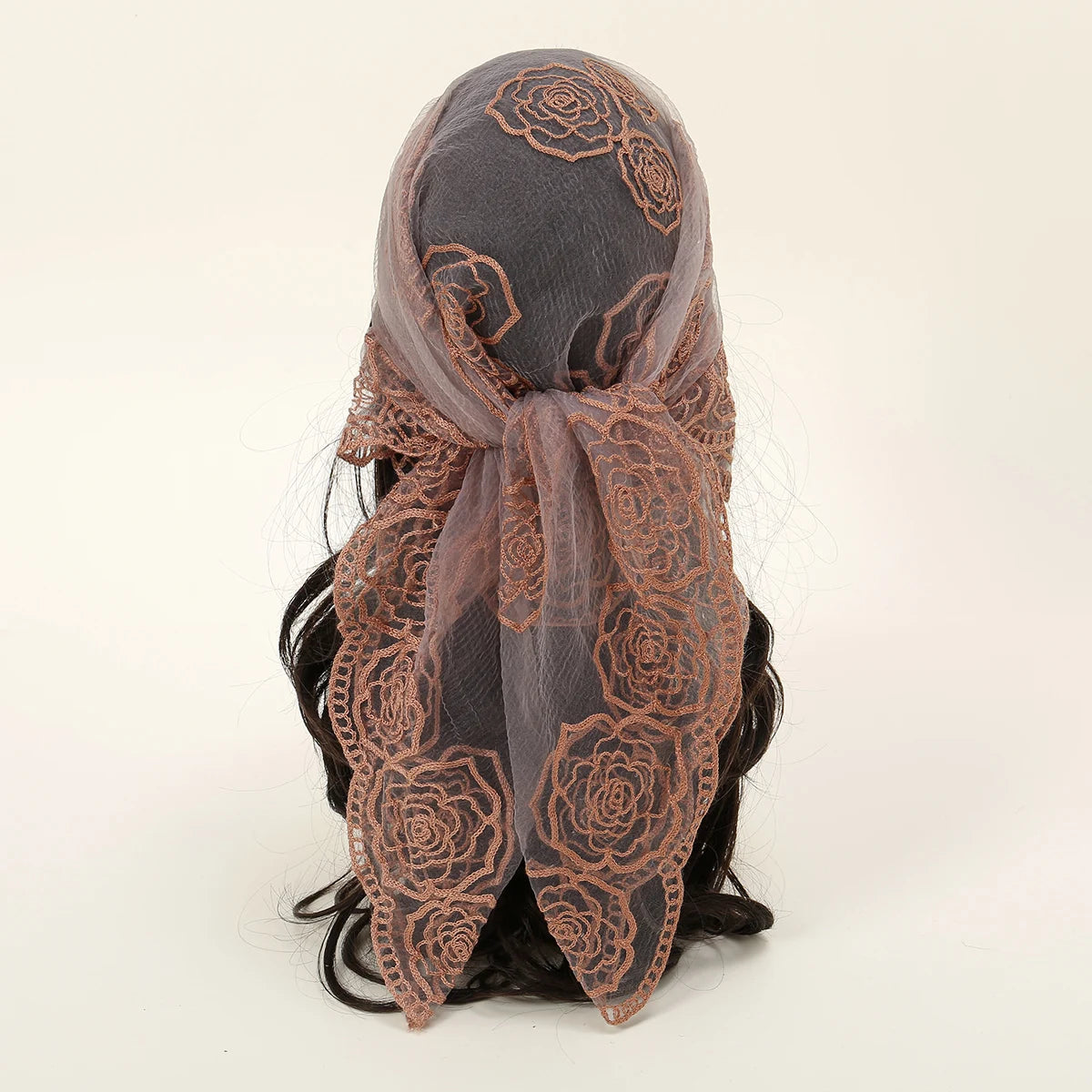 A dark brown floral embroidered lace bandana headscarf tied around a person's hair.