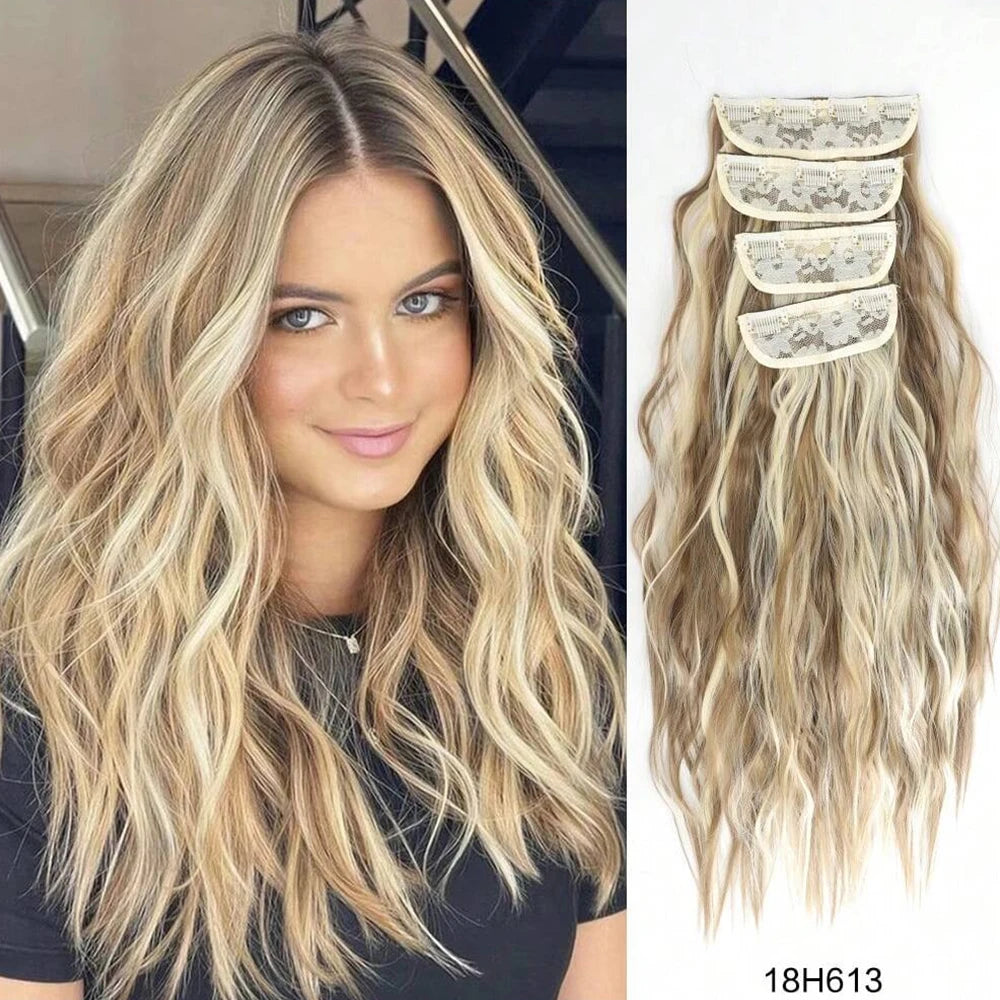 Una mujer rubia muestra extensiones de cabello ondulado clip-in largos con reflejos rubios claros.