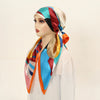 A model wears a colorful satin silk hijab headband cap with stripes of blue, orange, red, and cream.