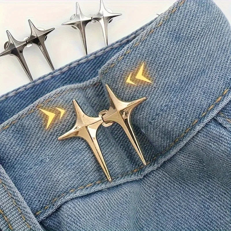 A pair of gold star-shaped decorative buttons are shown against a blue denim fabric.