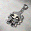 A clear acrylic keychain featuring a skull and crossbones design with a hood and a silver keyring.