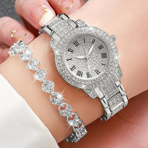A silver rhinestone heart watch set featuring a watch and a matching bracelet worn on a hand.