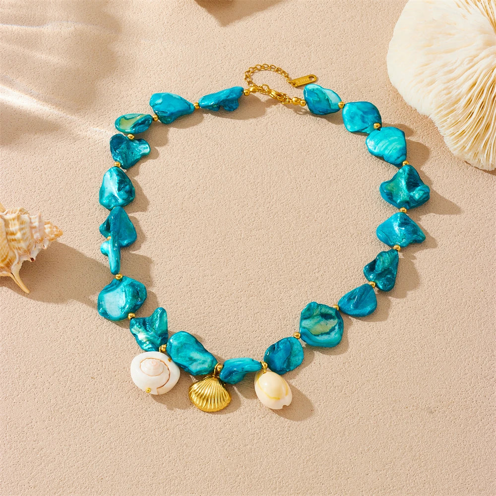 A gold-toned necklace featuring blue sea glass starfish and heart-shaped pendants on a gold chain.