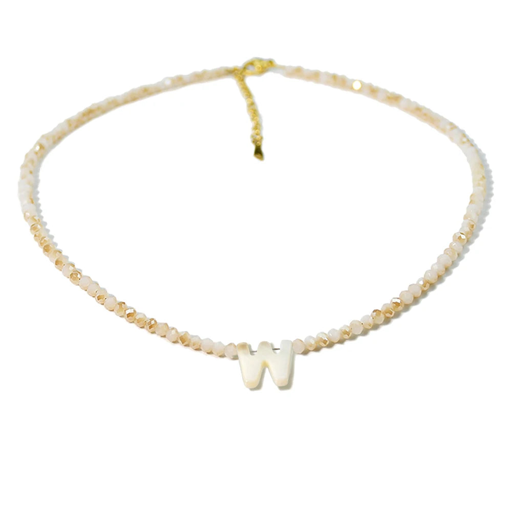 A delicate mother of pearl initial necklace featuring crystal accents.