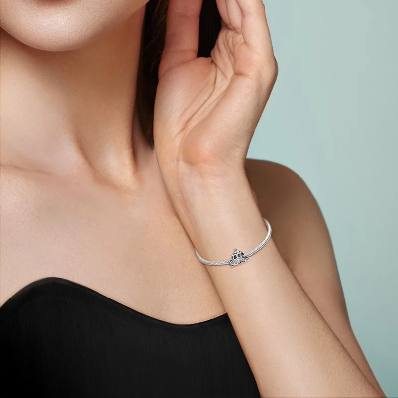 A close-up of a woman's wrist wearing a sterling silver devil's eye charm bracelet.