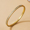 Goldfarbener Ring mit Pave-Diamanten und herzförmiges Armbandset auf hellem Hintergrund.
