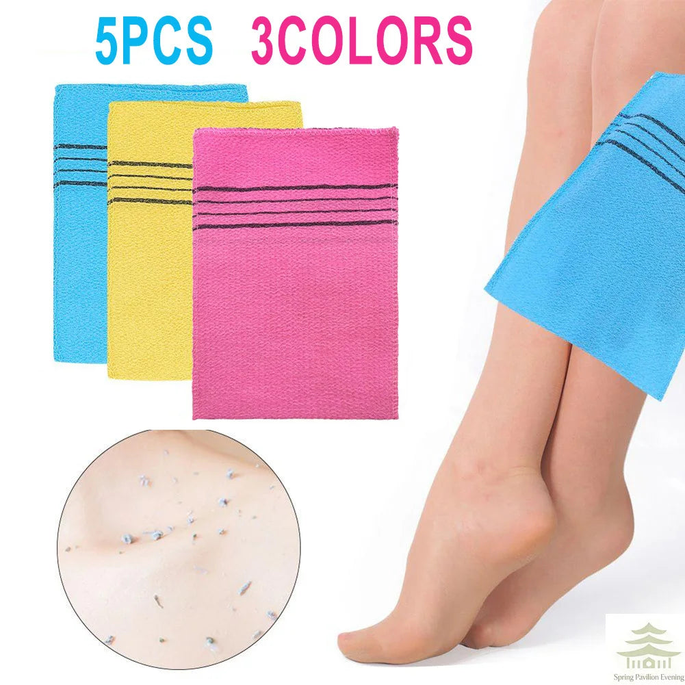 A set of five exfoliating bath washcloths in three colors blue, yellow, and pink shown next to a leg.
