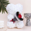 Bouquet de ours en peluche rose avec mousse blanche, ruban rouge et emballage foncé, sur fond clair.