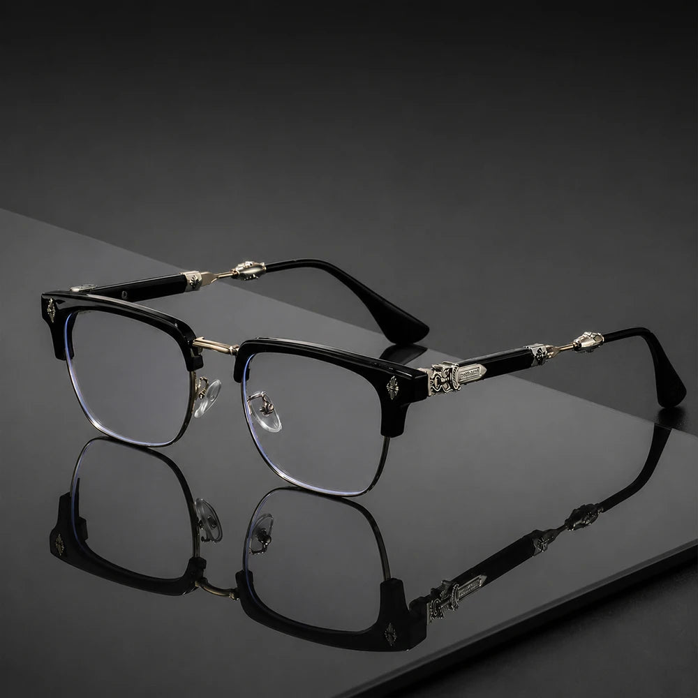 Une paire de lunettes vintage noires à demi-monture avec accents dorés, posées sur une surface sombre et réfléchissante.