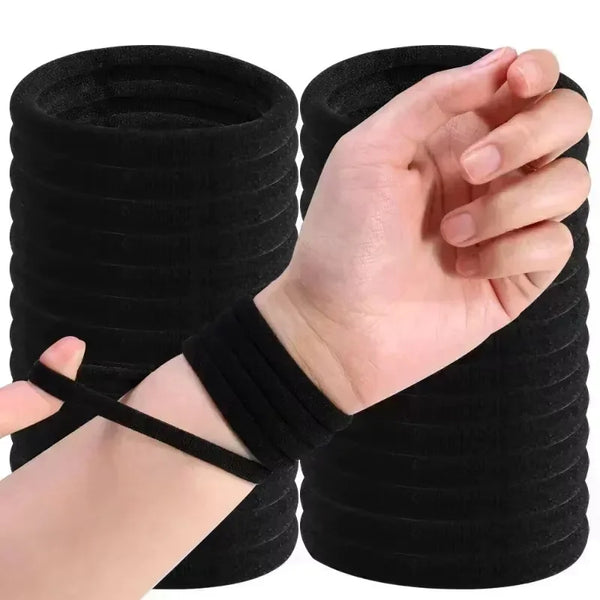A hand is shown holding a black elastic hair band or tie for ponytail and hair ties.