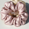 A bundle of pink and cream silk fabric gathered into a rosette shape for hair scrunchies.