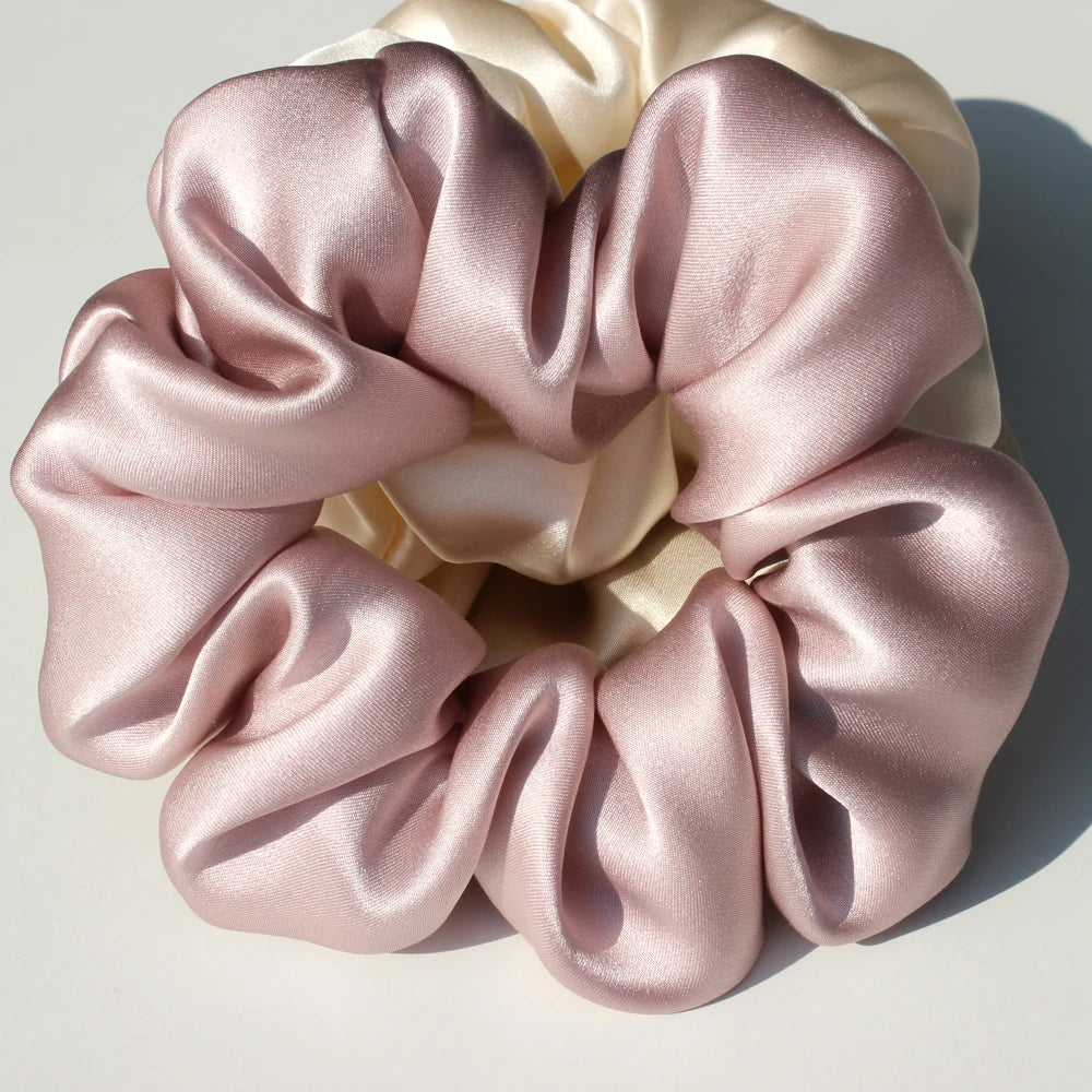 A bundle of pink and cream silk fabric gathered into a rosette shape for hair scrunchies.