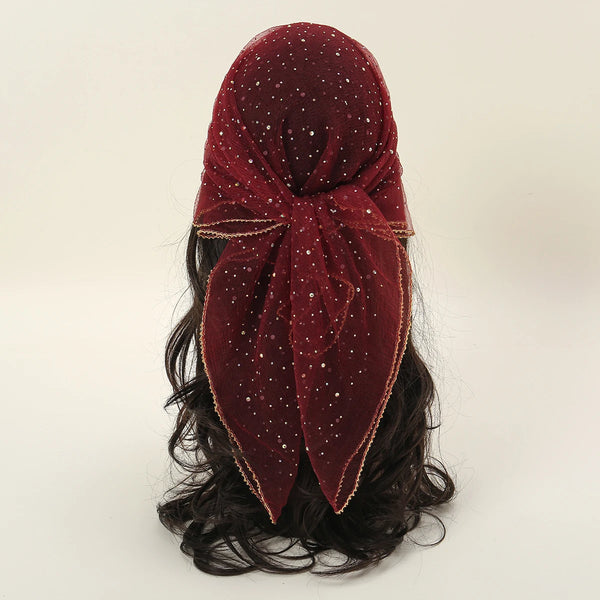 A deep maroon fashion hijab headscarf with small sparkling dots and a gold trim, styled on dark hair.