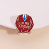 Broche émail rouge en forme de pull avec nœud papillon bleu et le texte Love Your Neighbor.